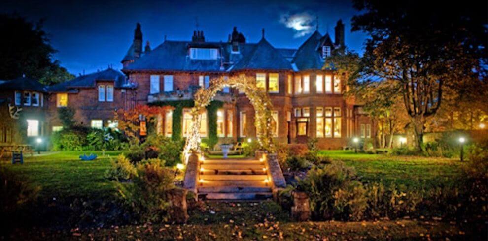 Red sandstone victorian building all lit up in the evening