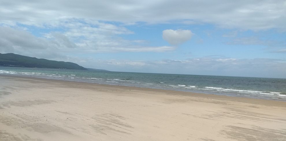 White sands and blue sea on a cloudy day.