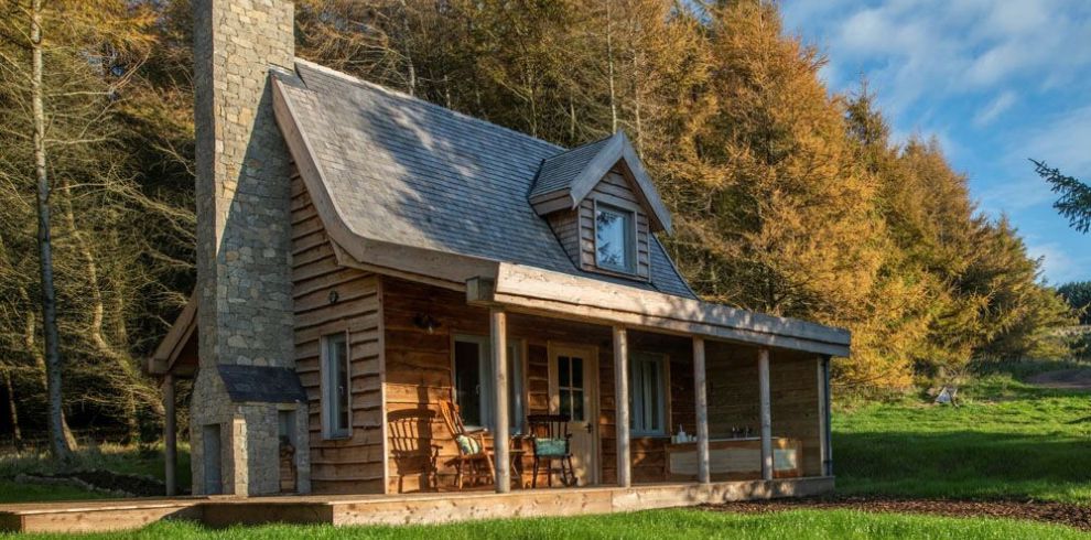 Cabins Outside in daytime with blue sky and a green forrest behind