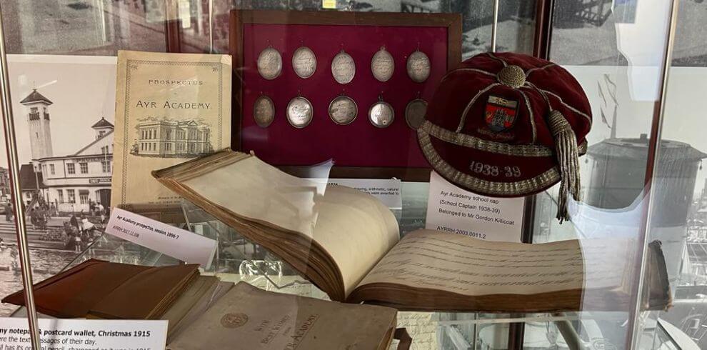 Display of Ayr Academy artefacts in a glass cabinet.