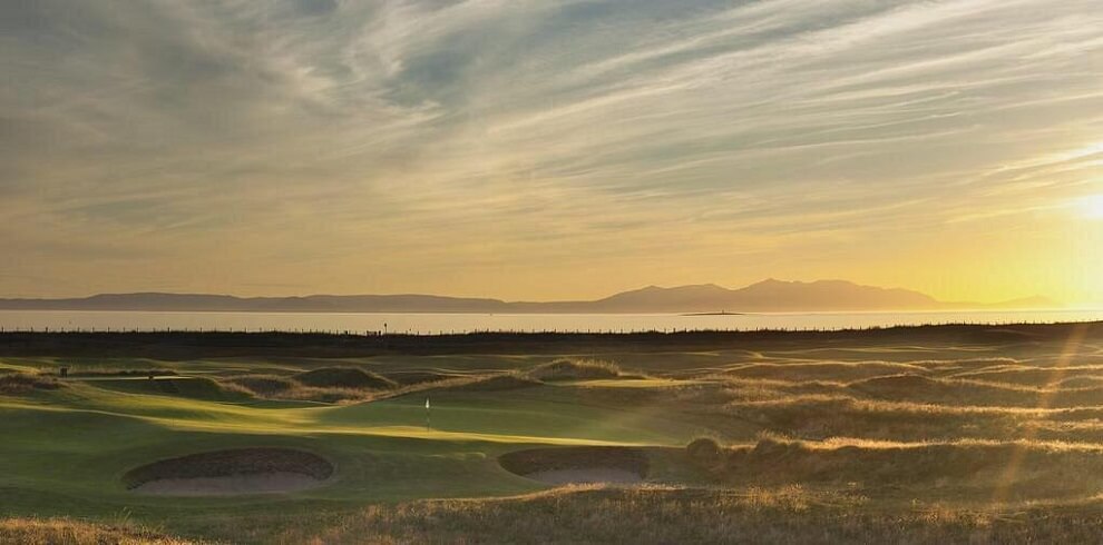 A photograph or Prestwick Golf Club with the Firth of Clyde and Arran in the background.