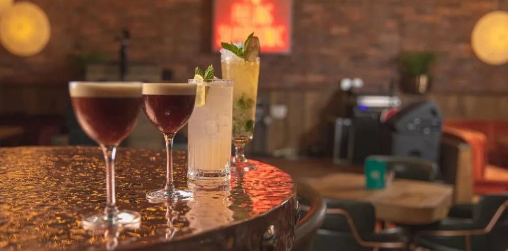 Row of cocktail drinks on a table.