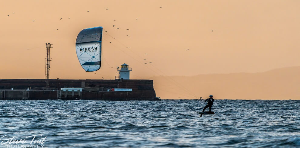 A person on the sea Kitesurfing.