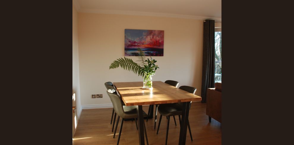 An image of a dining table with a vase on it.