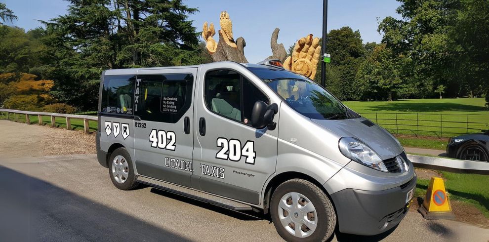 An image of a silver taxi parked on a street.