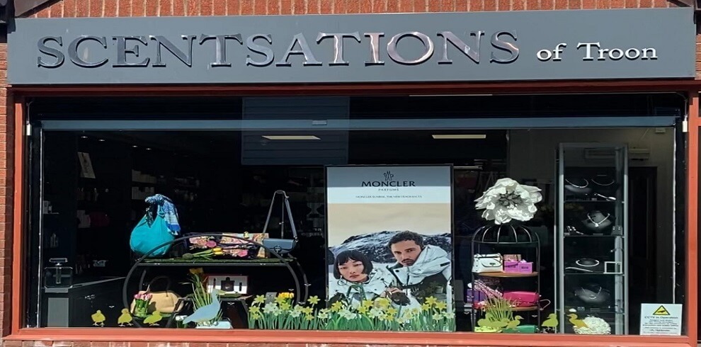 A picture of the shop window of Scentsations of Troon, showcasing a variety of colorful and elegantly displayed scented products.