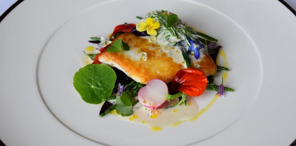 a fish dish served with edible flowers