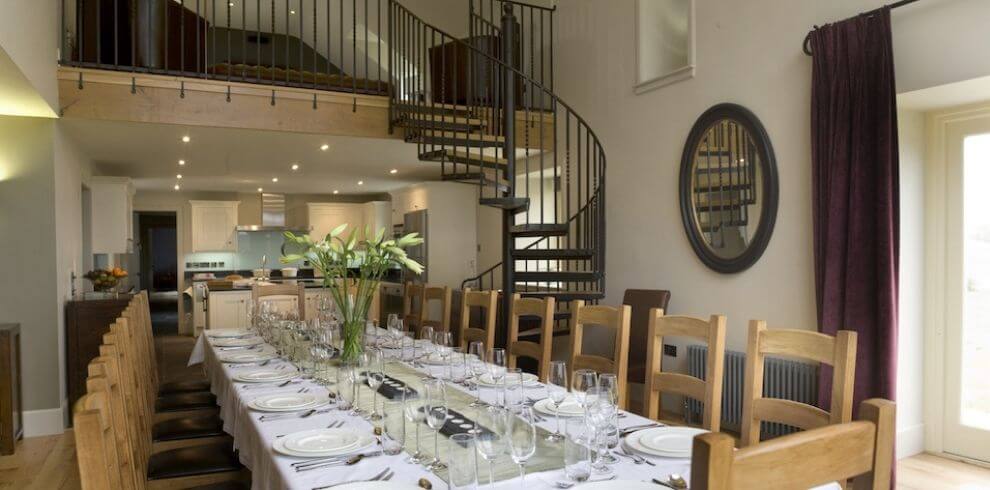 tastefully dressed dining table with spiral staircase in background