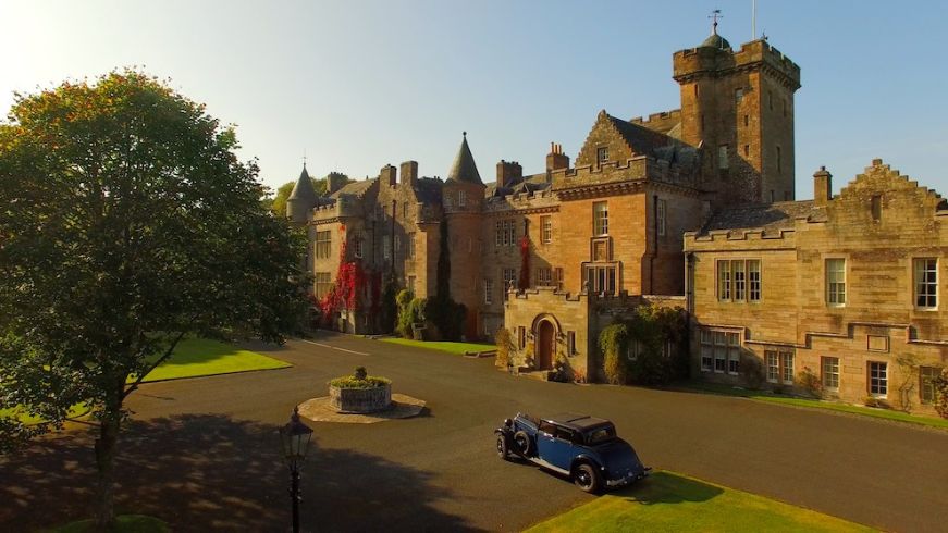 A majestic castle with vintage car outside