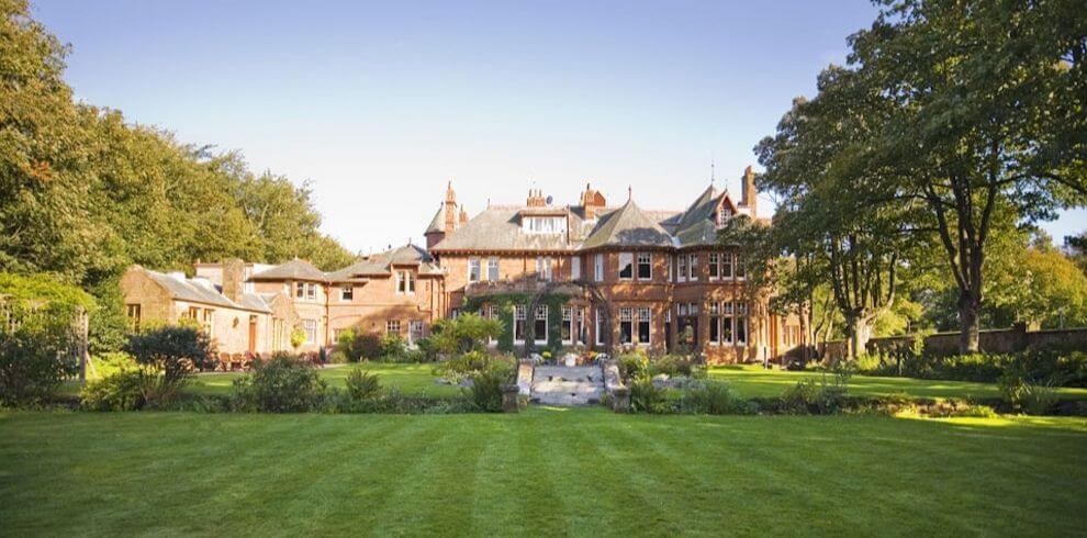 Victorian red sandstone building with beautiful gardens