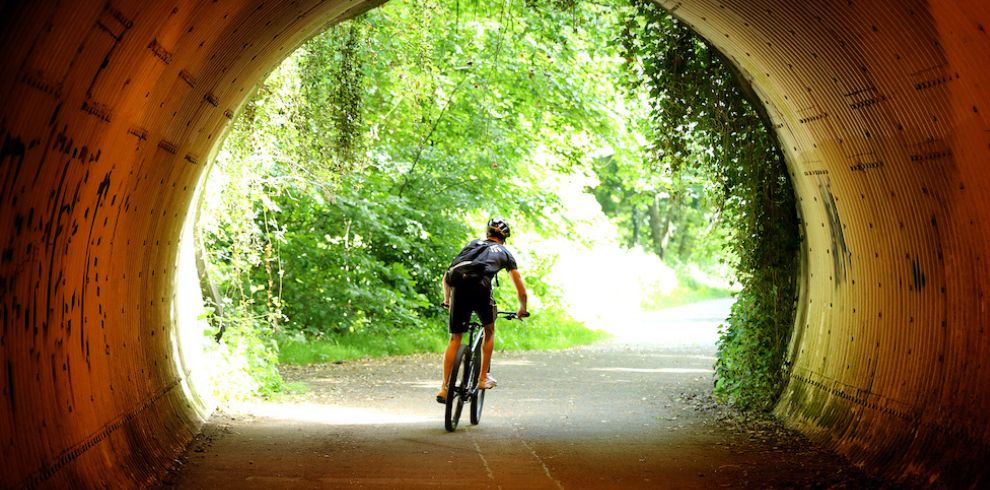 cyclist going through old railway line tunnel