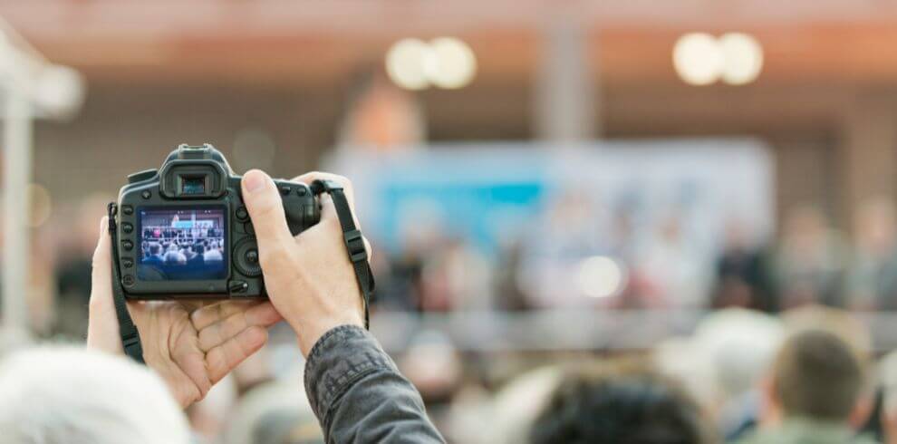 Person recording an event with a camera.