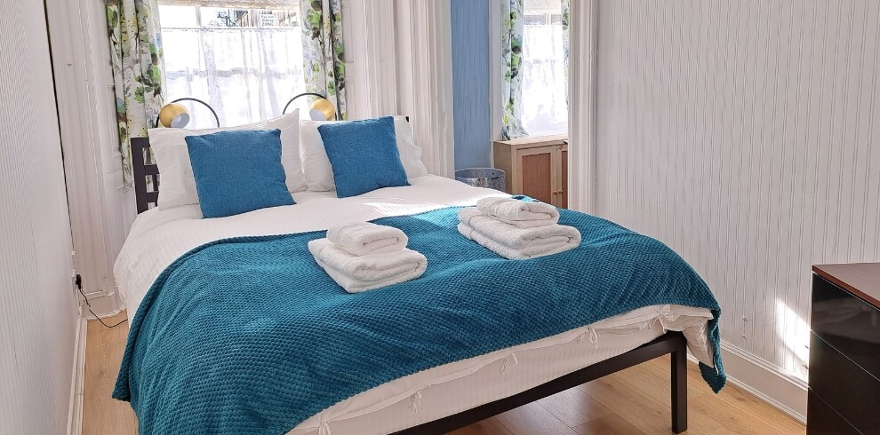 Cosy looking bed with turquoise bedding.