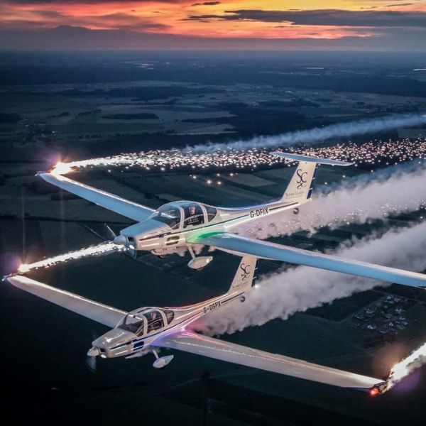 Grob 109b motor gliders in flight against a sunset sky.