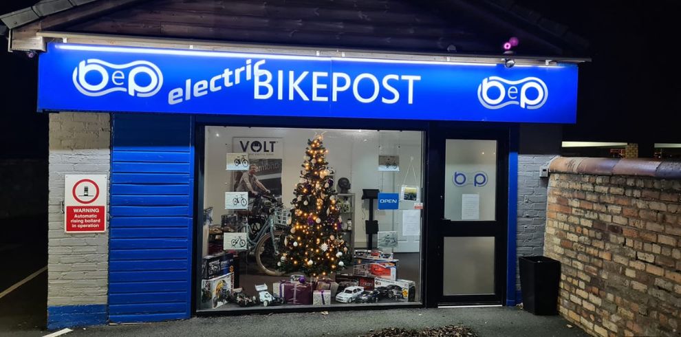 Electric Bikepost shop in Troon with a Christmas tree visible in the window.
