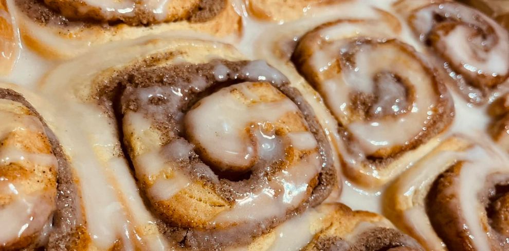 Tray of delicious looking iced cinnamon buns.