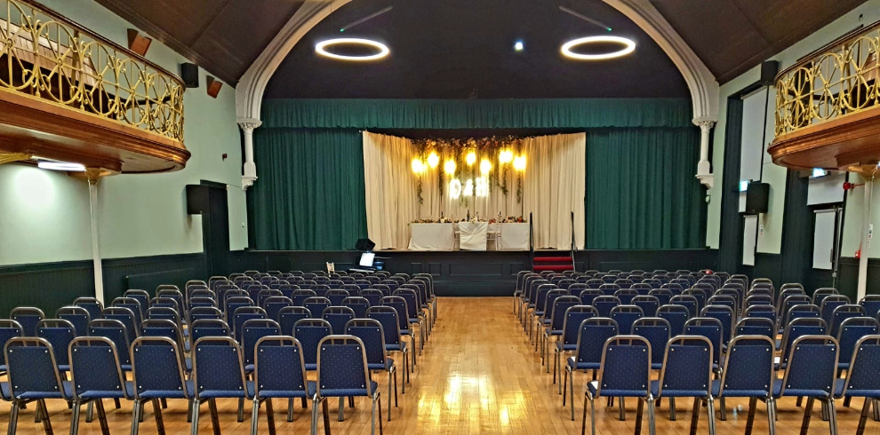 The interior of the town hall with chairs set up facing a stage.