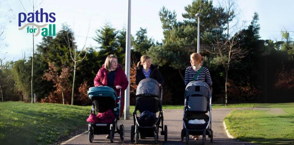 Image of a group of people with prams outdoors walking in nature.