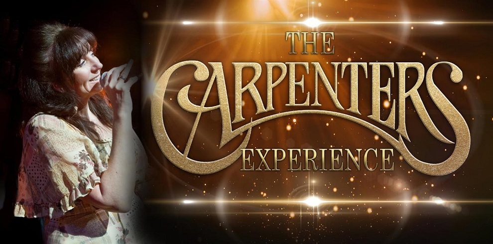 Title says The Carpenters Experience with a cast member singing under the spotlight.