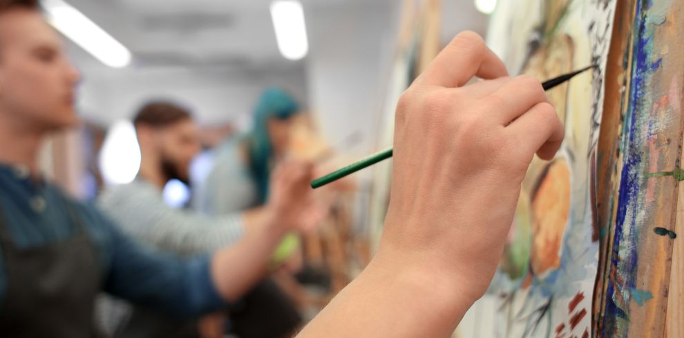 Students painting on a canvas.