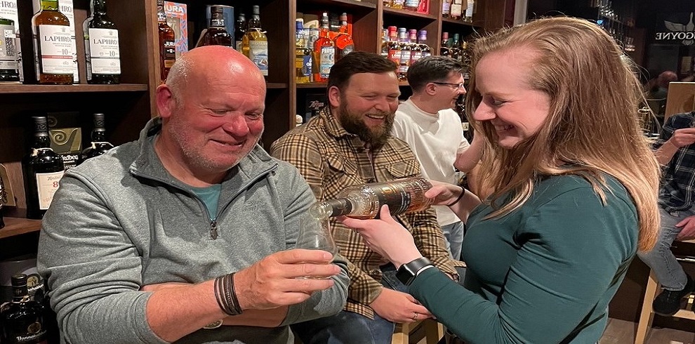 A picture of fourpeople enjoying a whisky tasting session.