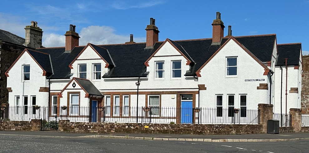 A photograph of Peel House Bed and Breakfast, a historic white building that once served as Girvan's old police station. The structure features traditional architecture with large windows and a neatly maintained exterior.