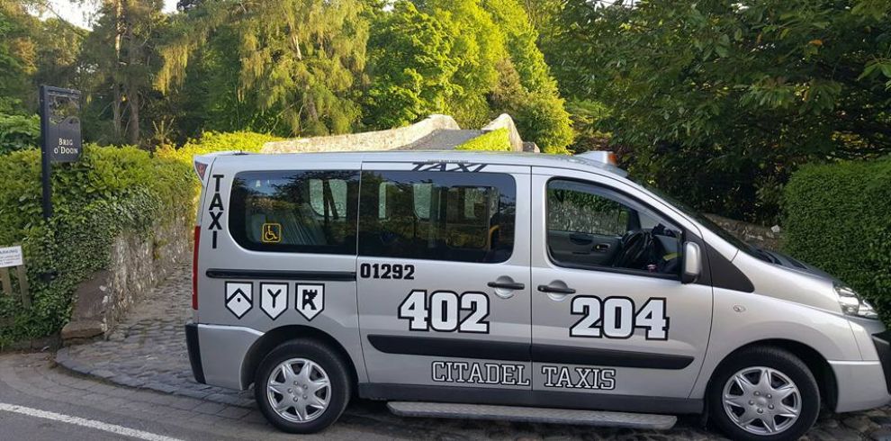An image of a silver taxi parked on a street.