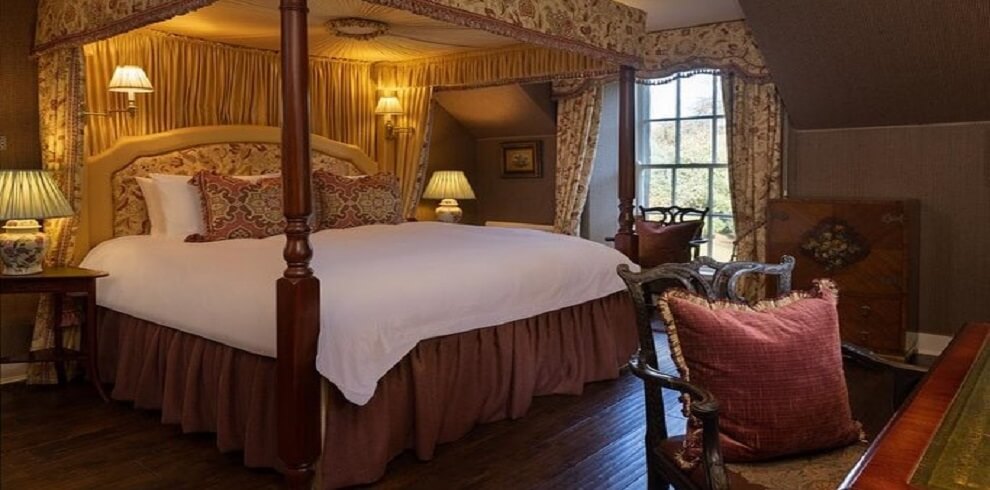 A picture of a bedroom with a four poster bed.