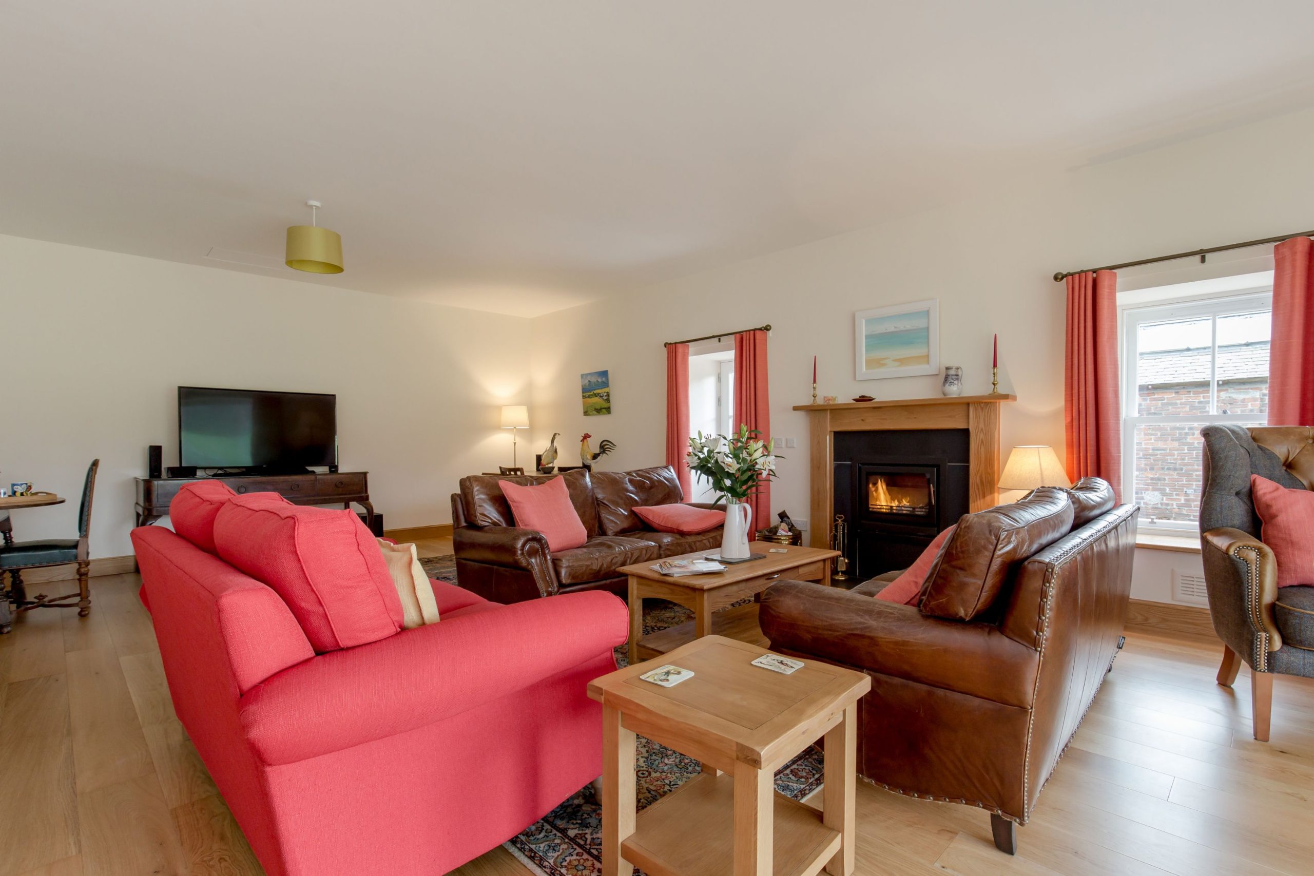 An image of a lounge with a fireplace, chairs and sofas.