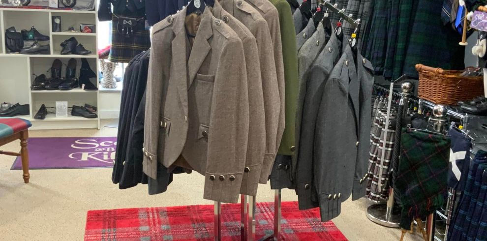 A picture of a rail of kilts and blazers.