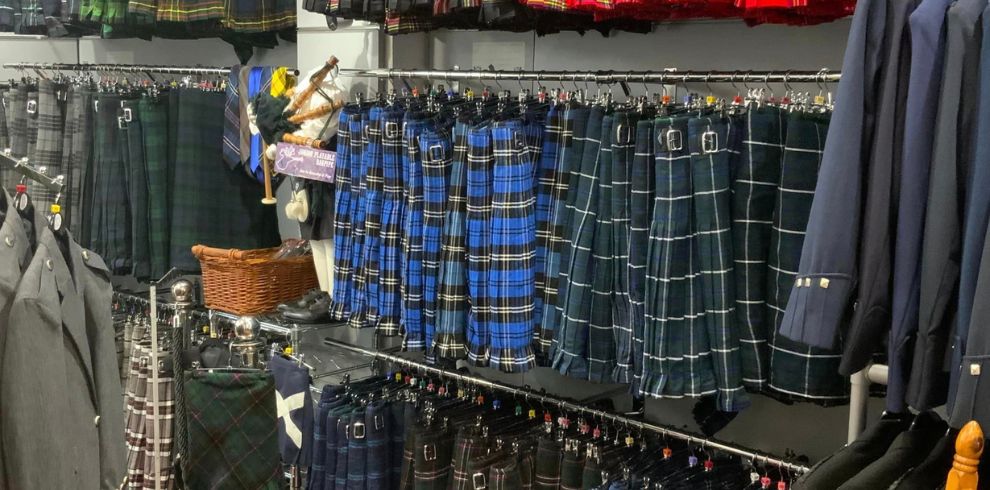 A picture of a rail of kilts and blazers.