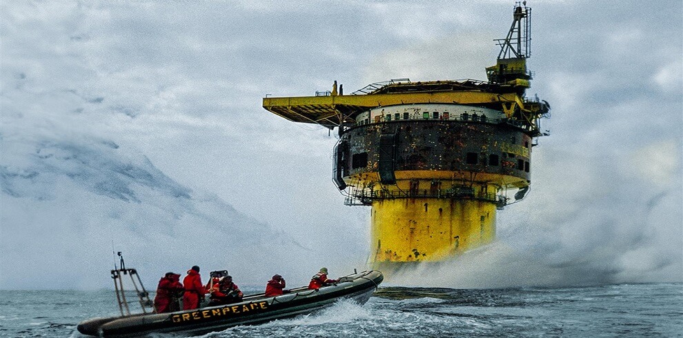 A picture of the crew in a speed boat, approaching an oil platform.