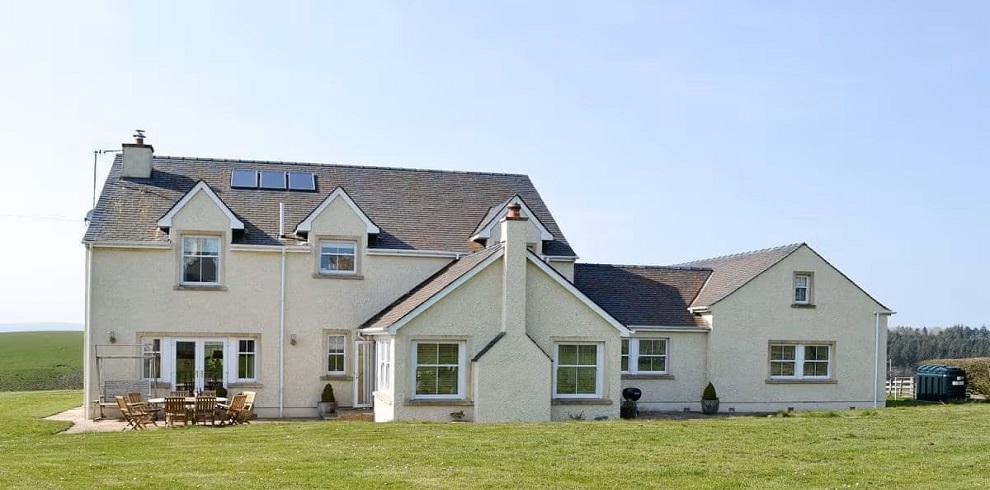 A picture of the outside of Yonderton House. Sitting in the country side with blue skies.