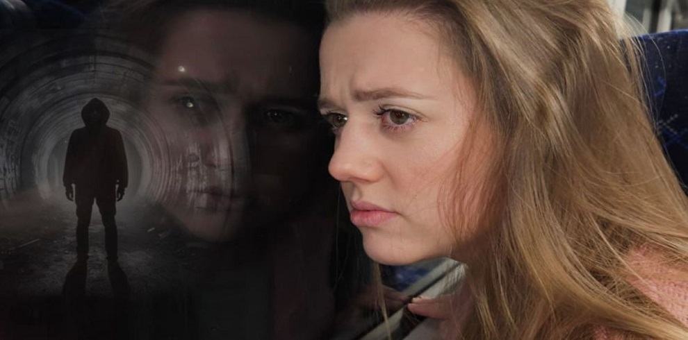 Promotional image for the theatre production of The Girl on the Train. A woman with long blonde hair stares pensively out of a window, her face filled with concern. Reflected in the glass is a shadowy figure standing in a dimly lit tunnel, adding a sense of mystery and tension.