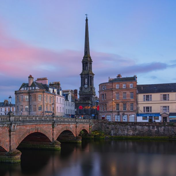 Stone bridge over river with Town hall spire in the distance.