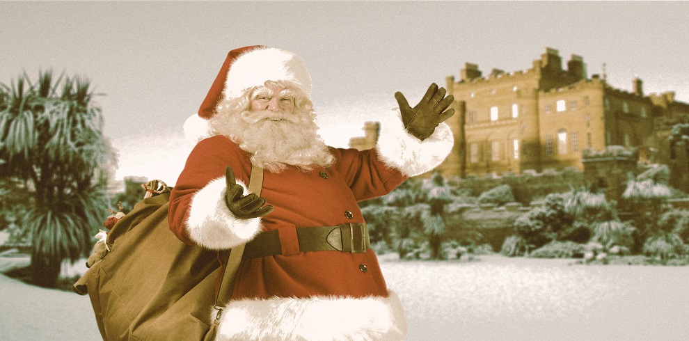 A [icture of Santa looking joyous posing in front of snowy scene Cluzean Castle.