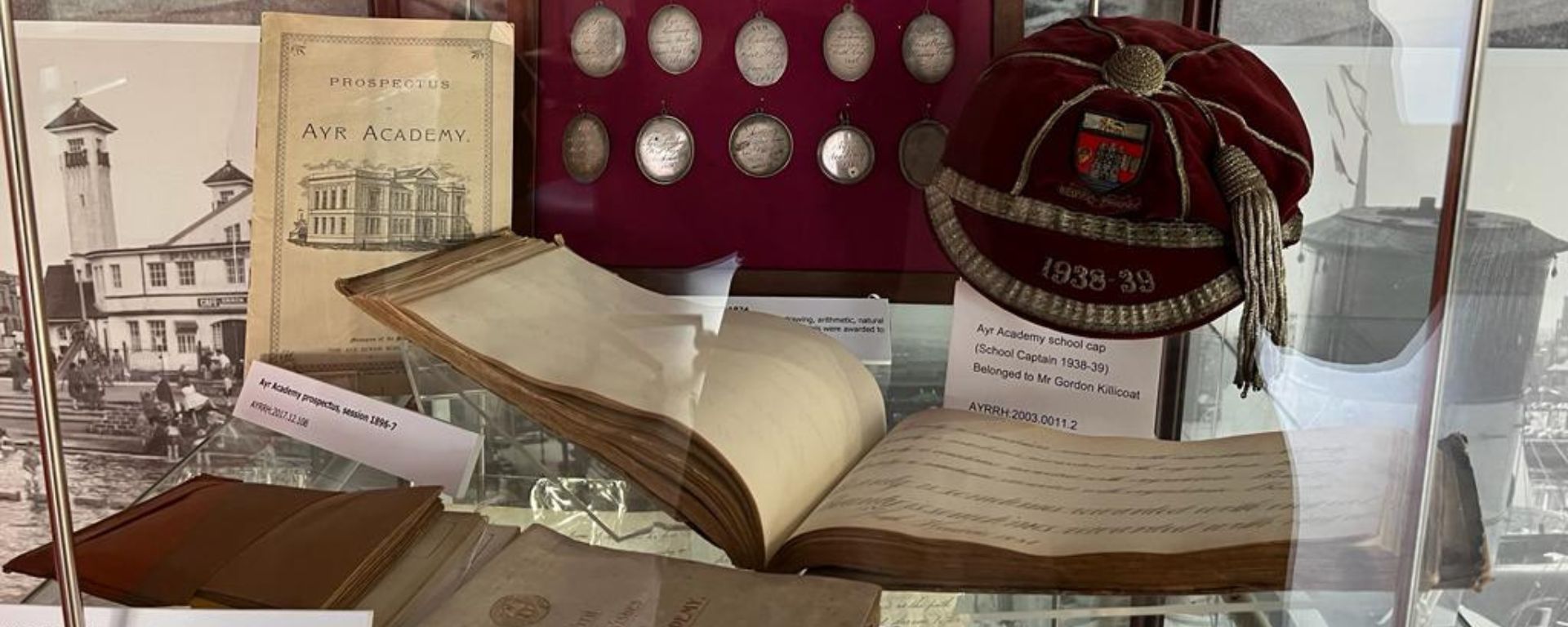 Display of Ayr Academy artefacts in a glass cabinet.