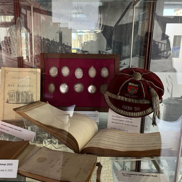 Display of Ayr Academy artefacts in a glass cabinet.