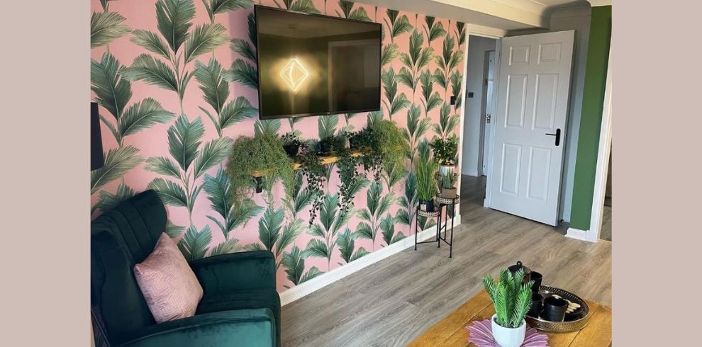 An image of a living room with a chair and a TV on the wall.