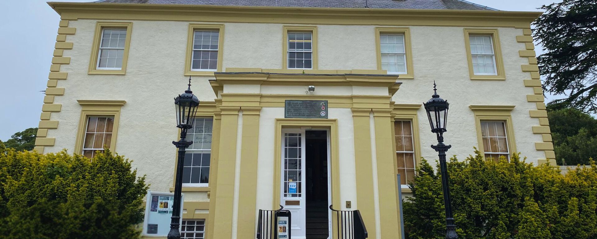 Exterior of large mansion house with open door.