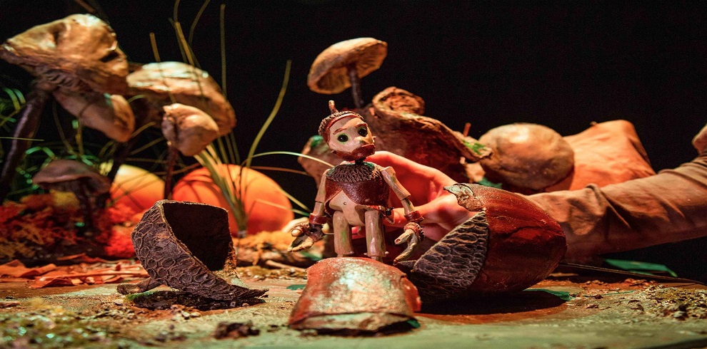 A picture of a puppet scene with little acorns.