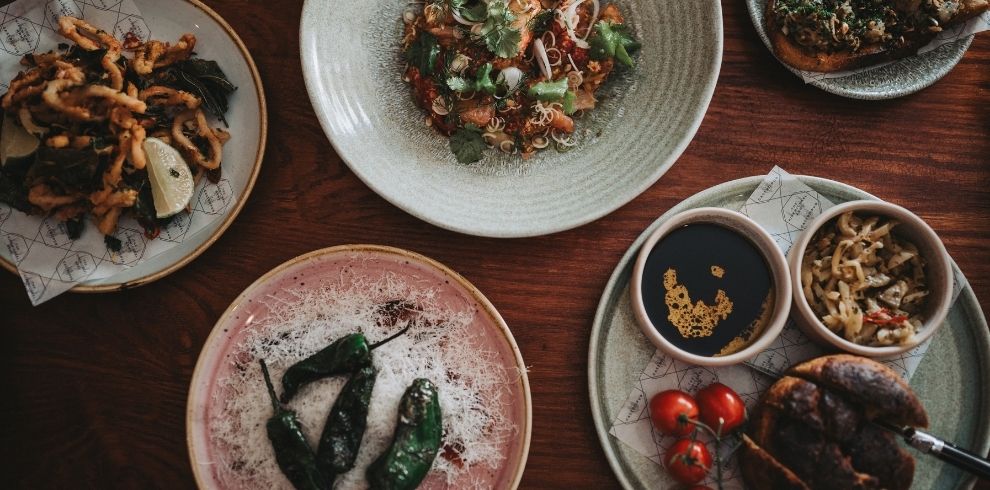 An image of various plates of food including squid on a plate.