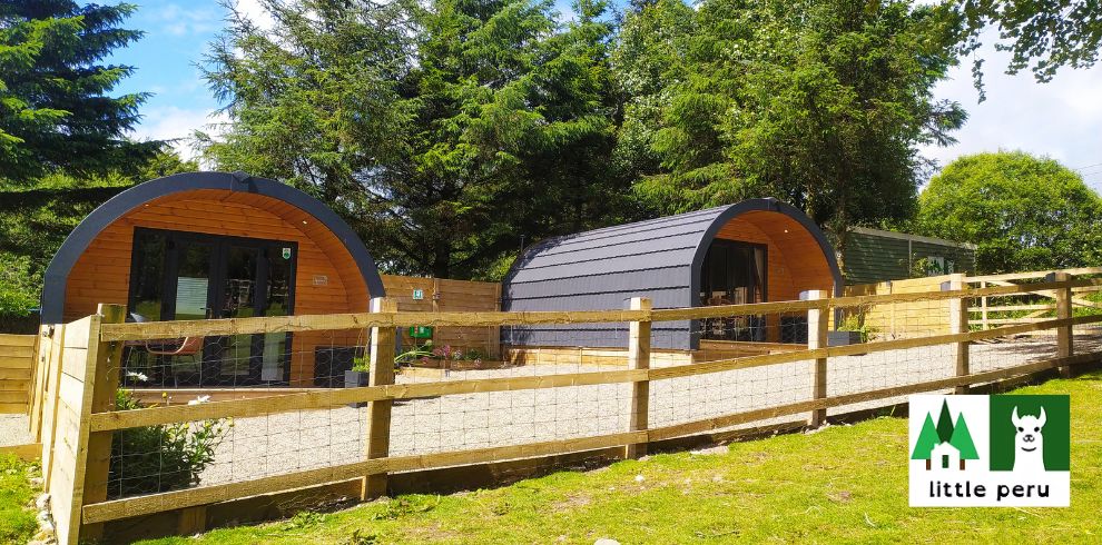 An image of two glamping pods on a sunny day.