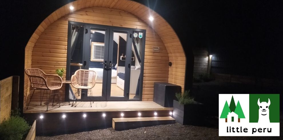 An image of a glamping pod at night all lit up.