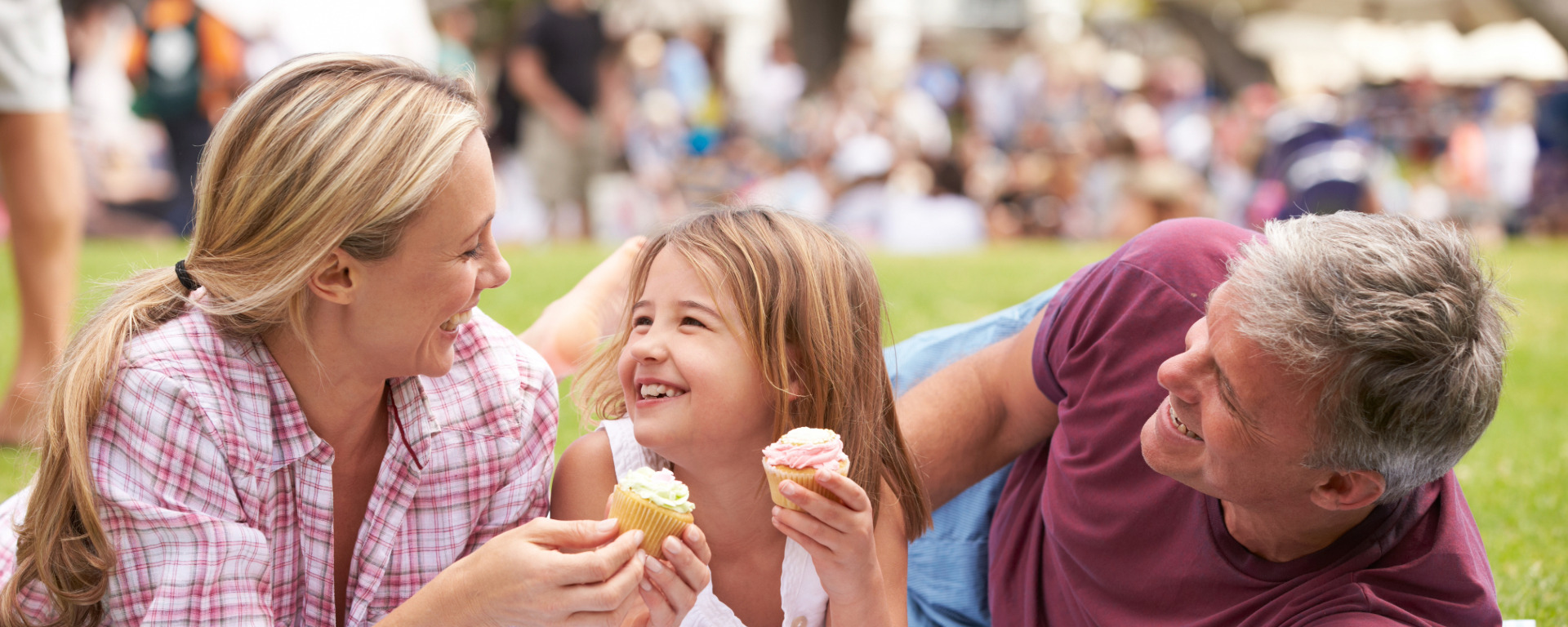 Family enoying cupcakes and at outside event