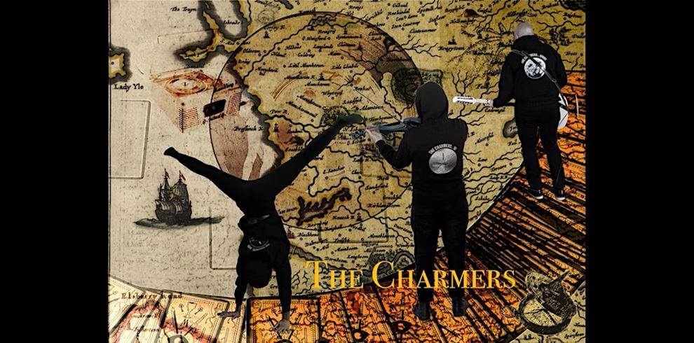 Three people wearing black hoodies with a circular logo on the back, labeled 'The Charmers,' are superimposed onto a vintage nautical map background. One person is performing a handstand on the left, another stands in the center facing the map while holding a musical instrument, and a third stands on the right playing an electric guitar. All are on a wooden dock or platform that appears to float over the map. The title 'The Charmers' is displayed in gold text at the bottom right corner, near a compass rose illustration.