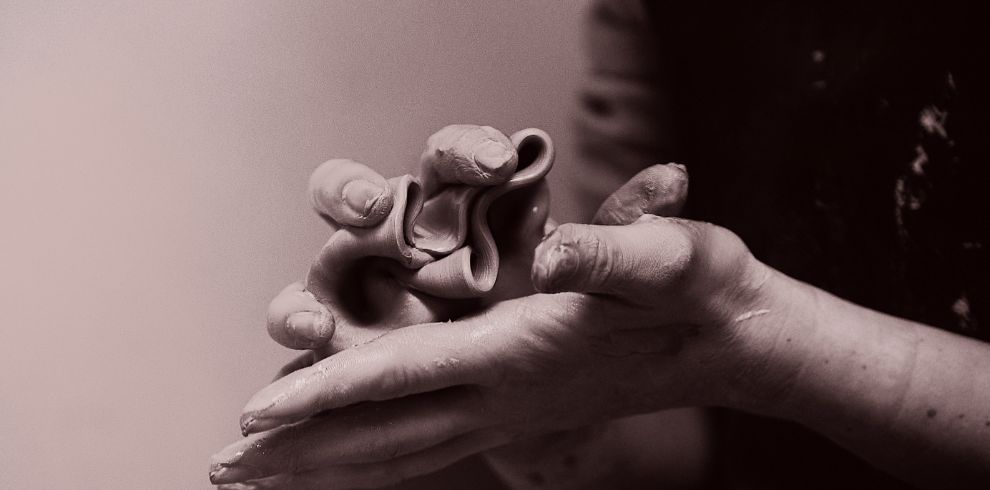 Image of hands molding clay.