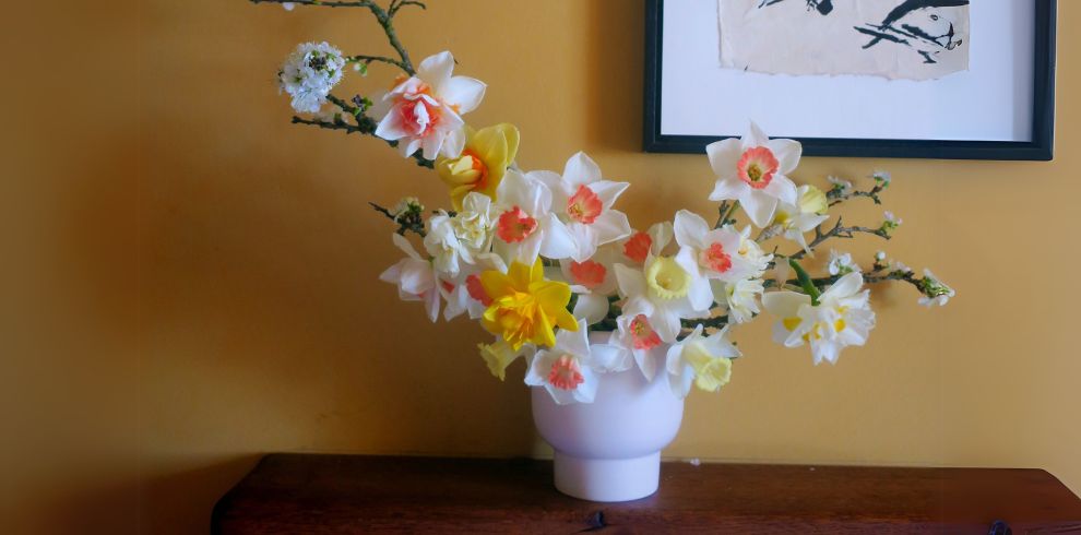 An image of a floral display in a vase on a table.