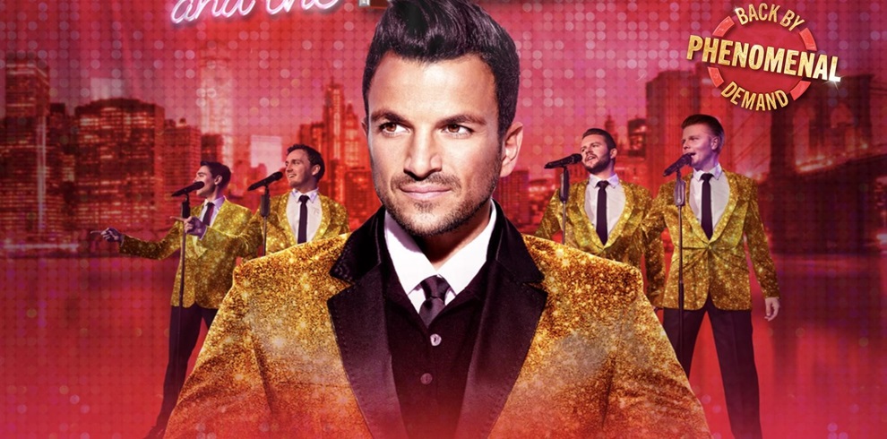 Four men wearing gold glittery jackets, black pants, and white shirts with black ties, standing in front of microphones on a stage. The background is red with an urban skyline design. Their faces are blurred, and the top right corner features the text 'BACK BY PHENOMENAL DEMAND.