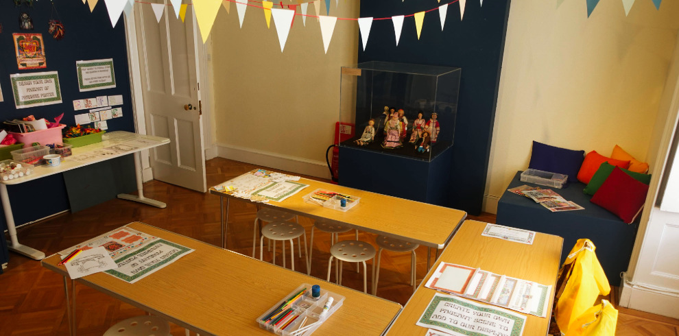 A room decorating with colourful bunting. Tables set-up for colouring activities for children.